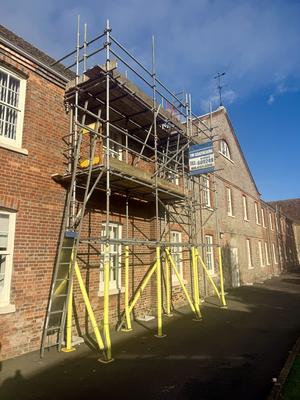 Historic brick building scaffolding with THF banner
