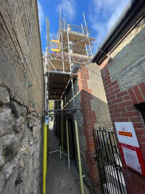 Narrow alleyway scaffolding near Royal Mail for building work