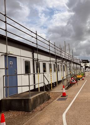 Portacabin frontage scaffolding with safety signage
