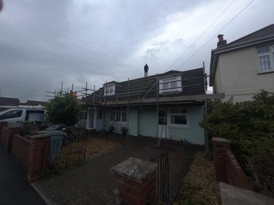 Bungalow scaffolding with worker on roof