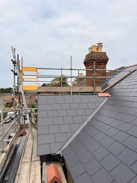 Rooftop scaffolding with new slate tiles