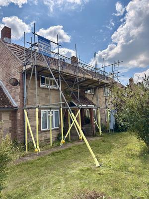 Stone house front scaffolding with THF banner
