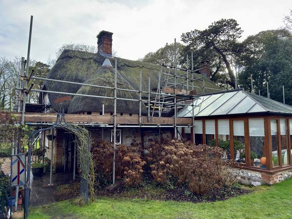 Thatched cottage with conservatory scaffolding