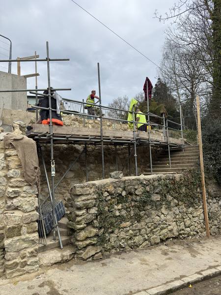 Retaining wall scaffolding with workers